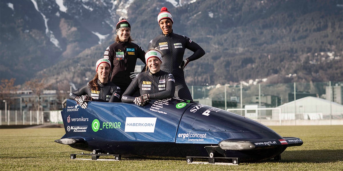 Kati Baierl standing with her bobsled team.
